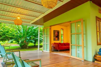 a living room with a red couch and a green wall at Quintaesencia Arte y Naturaleza in Guápiles