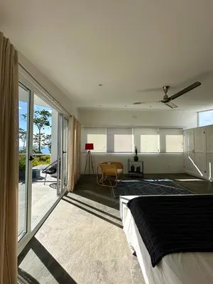 a bedroom with a bed and a view of a patio at Ocean View Villa 2min to beach - Casa Cantini in Montezuma