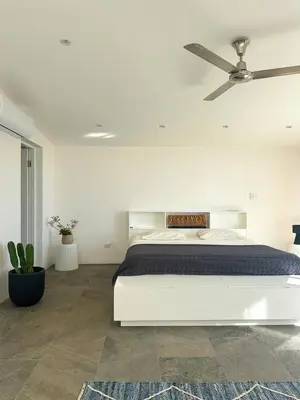 a white bedroom with a bed and a ceiling fan at Ocean View Villa 2min to beach - Casa Cantini in Montezuma