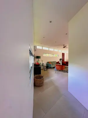 a living room with a white wall and a living room at Ocean View Villa 2min to beach - Casa Cantini in Montezuma