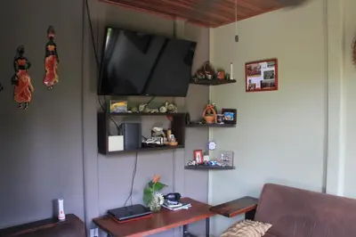 a living room with a flat screen tv on the wall at La Dulce Casita in Uvita