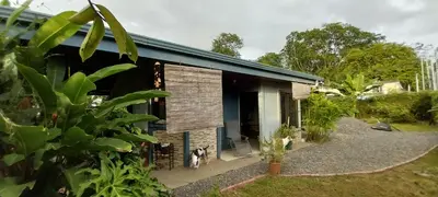 a house with a dog standing outside of it at La Dulce Casita in Uvita