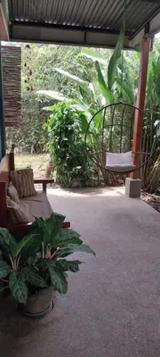 a patio with a bench and a plant in a building at La Dulce Casita in Uvita