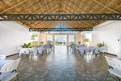 a banquet hall with white tables and chairs at Tardes Doradas in Quepos