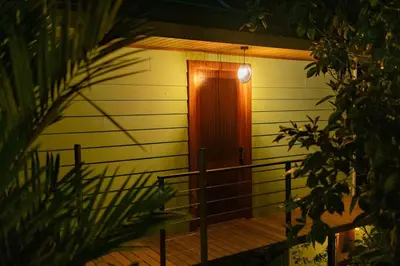 a door to a house with a light on it at Tardes Doradas in Quepos