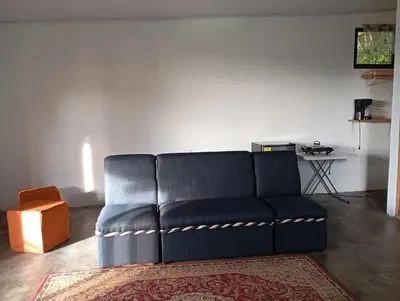 a blue couch in a living room with a rug at Casa la Rosa third floor 5 in Quepos