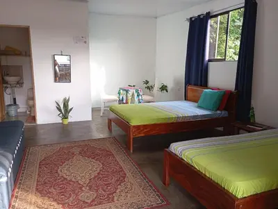a living room with two beds and a couch at Casa la Rosa third floor 5 in Quepos