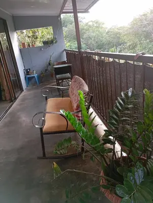 a porch with a chair and a plant at Casa la Rosa third floor 5 in Quepos