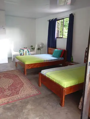 a room with three beds and a window at Casa la Rosa third floor 5 in Quepos