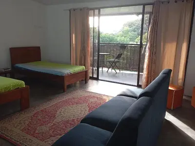 a living room with a couch and a balcony at Casa la Rosa third floor 5 in Quepos