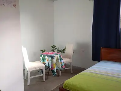 a table with two chairs and a plant in a room at Casa la Rosa third floor 5 in Quepos
