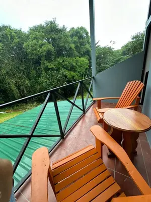 a balcony with two tables and chairs and a view of the water at Aracari Eco Lodge in Corazón de Jesús
