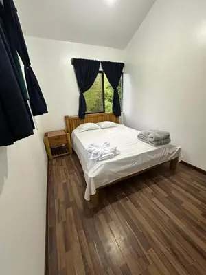 a small bedroom with a bed and a window at Aracari Eco Lodge in Corazón de Jesús