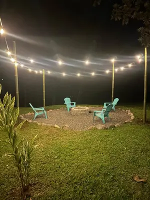 two green chairs and a fire pit at night at Aracari Eco Lodge in Corazón de Jesús