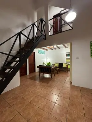 a room with a staircase and a living room at Aracari Eco Lodge in Corazón de Jesús