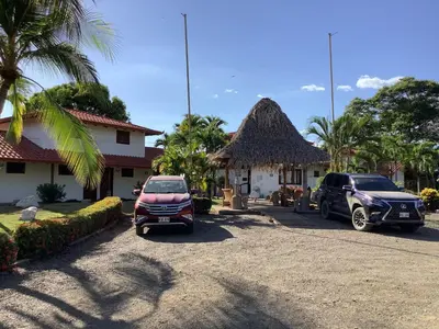 two cars parked in a parking lot in front of a house at Casa Caletas Boutique Hotel in Puerto Coyote