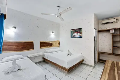 a bedroom with two beds and a ceiling fan at Hotel Tamarindo INN - 1 mi to Tamarindo Beach in Tamarindo