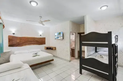 a bedroom with two beds and a bunk bed at Hotel Tamarindo INN - 1 mi to Tamarindo Beach in Tamarindo