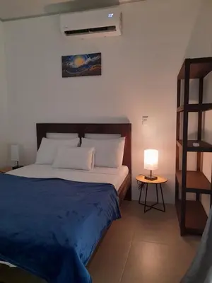 a bedroom with a bed with a blue blanket and a lamp at Moon Home Sea #4 in Playa hermosa