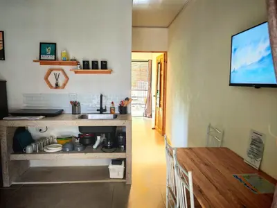 a kitchen with a table and a television on a wall at Moon Home Sea #4 in Playa hermosa