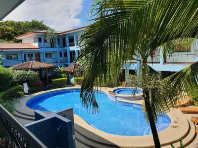 a swimming pool with a palm tree next to a building at Apartment hotel Marina Loft 207 in Coco