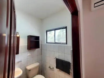 a bathroom with a toilet and a sink and a window at Marina Loft Condos 223 in Coco