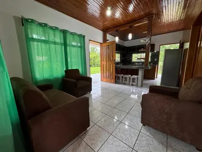 a living room with two couches and a kitchen at Alojamiento tranquilo rodeado de paz y serenidad in Río Negro
