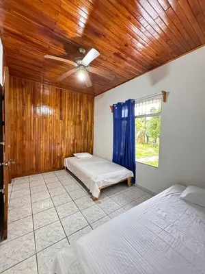 a bedroom with two beds and a ceiling fan at Alojamiento tranquilo rodeado de paz y serenidad in Río Negro