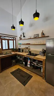 a large kitchen with a counter and a refrigerator at Zoa Villas - Santa Teresa - 2 min walk to beach in Santa Teresa Beach