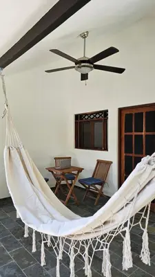 a hammock in a living room with a table at Zoa Villas - Santa Teresa - 2 min walk to beach in Santa Teresa Beach