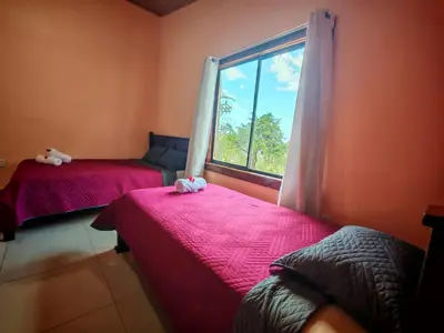 two beds in a room with a window at Monteverde Twins in Monteverde Costa Rica