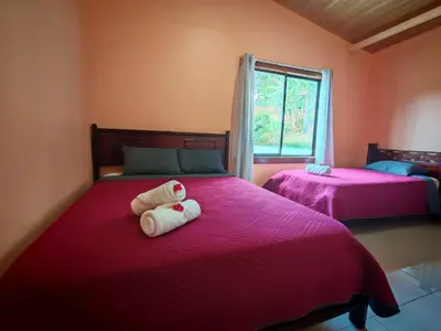 a bedroom with two beds with pink sheets at Monteverde Twins in Monteverde Costa Rica