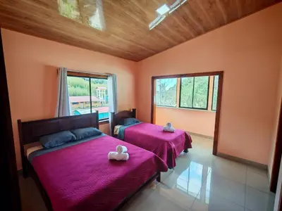 a bedroom with two beds with pink sheets at Monteverde Twins in Monteverde Costa Rica