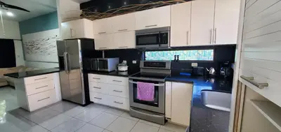 a kitchen with white cabinets and black counter tops at Vista perfecta dos ap 8 in Artola
