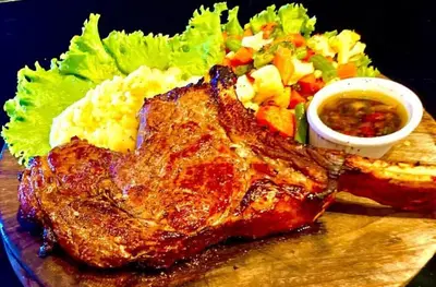 a plate of food with a steak and a salad at Vista Condor Lodge in Puerto Viejo