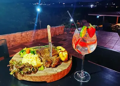 a plate of food and a glass of wine on a table at Vista Condor Lodge in Puerto Viejo