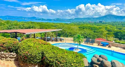 a resort swimming pool with a view of the mountains at Vista Condor Lodge in Puerto Viejo
