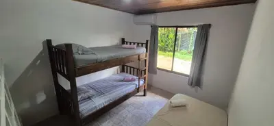 two bunk beds in a room with a window at Abacaxi Box Studios in Santa Teresa Beach