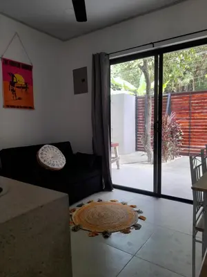a living room with a couch and a large sliding glass door at Moon Home Sun #3 in Playa hermosa