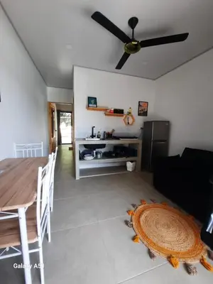a living room with a table and a ceiling fan at Moon Home Sun #3 in Playa hermosa