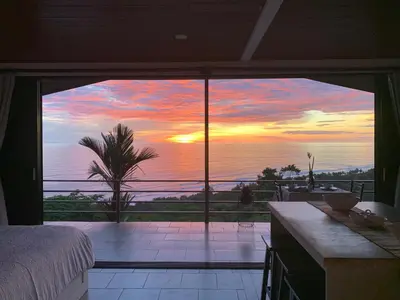 a bedroom with a view of the ocean at sunset at Villa Del Mar 3 Spectacular ocean view in Savegre