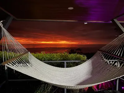 a hammock with a sunset in the background at Villa Del Mar 3 Spectacular ocean view in Savegre