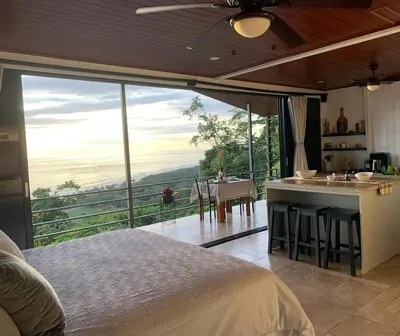 a bedroom with a bed and a kitchen with a view at Villa Del Mar 3 Spectacular ocean view in Savegre