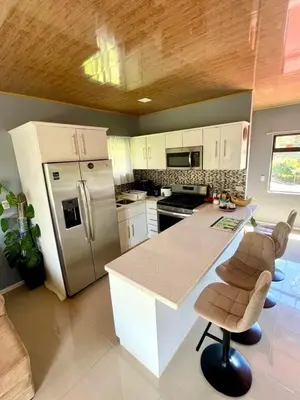 a kitchen with a refrigerator and a counter with chairs at Apartamento Marina in Monteverde Costa Rica