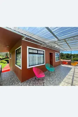 a patio with colorful chairs and a building with a roof at Apartamento Marina in Monteverde Costa Rica
