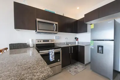 a kitchen with a stove and a refrigerator at Beautiful beachfront condo, amazing pool in Bejuco
