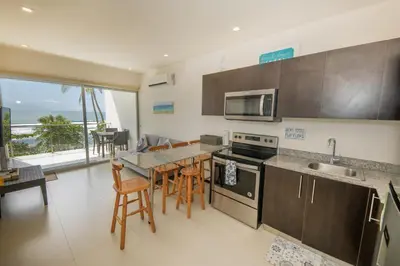 a kitchen with a table and chairs and a counter top at Beautiful beachfront condo, amazing pool in Bejuco