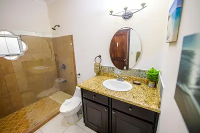 a bathroom with a sink and a toilet and a mirror at Villa Sirena Del Mar by Vacation Pura Vida in Bejuco