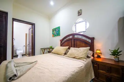 a bedroom with a large bed with a wooden headboard at Villa Sirena Del Mar by Vacation Pura Vida in Bejuco