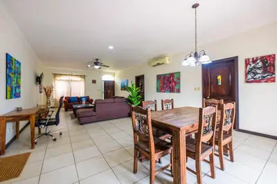 a dining room and living room with a table and chairs at Villa Sirena Del Mar by Vacation Pura Vida in Bejuco
